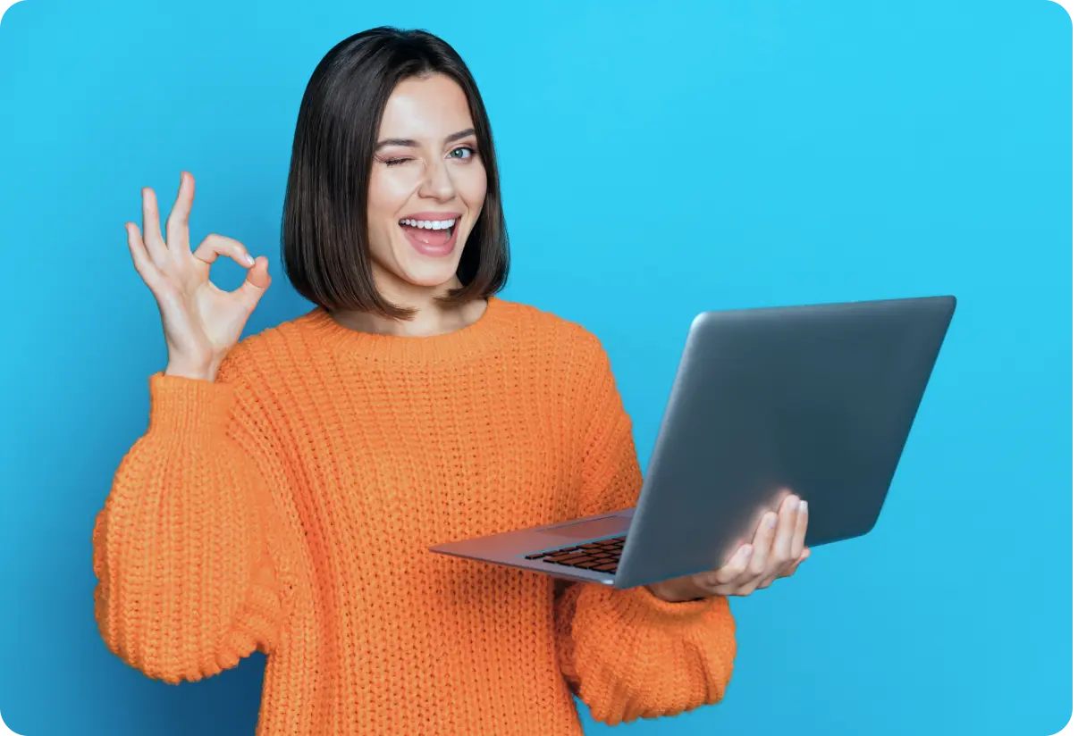 Cheerful female with laptop showing ‘perfect’ gesture